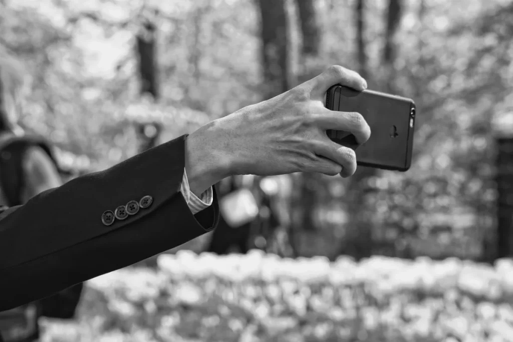 Seseorang sedang menatap layar smartphone dengan penuh pertimbangan
